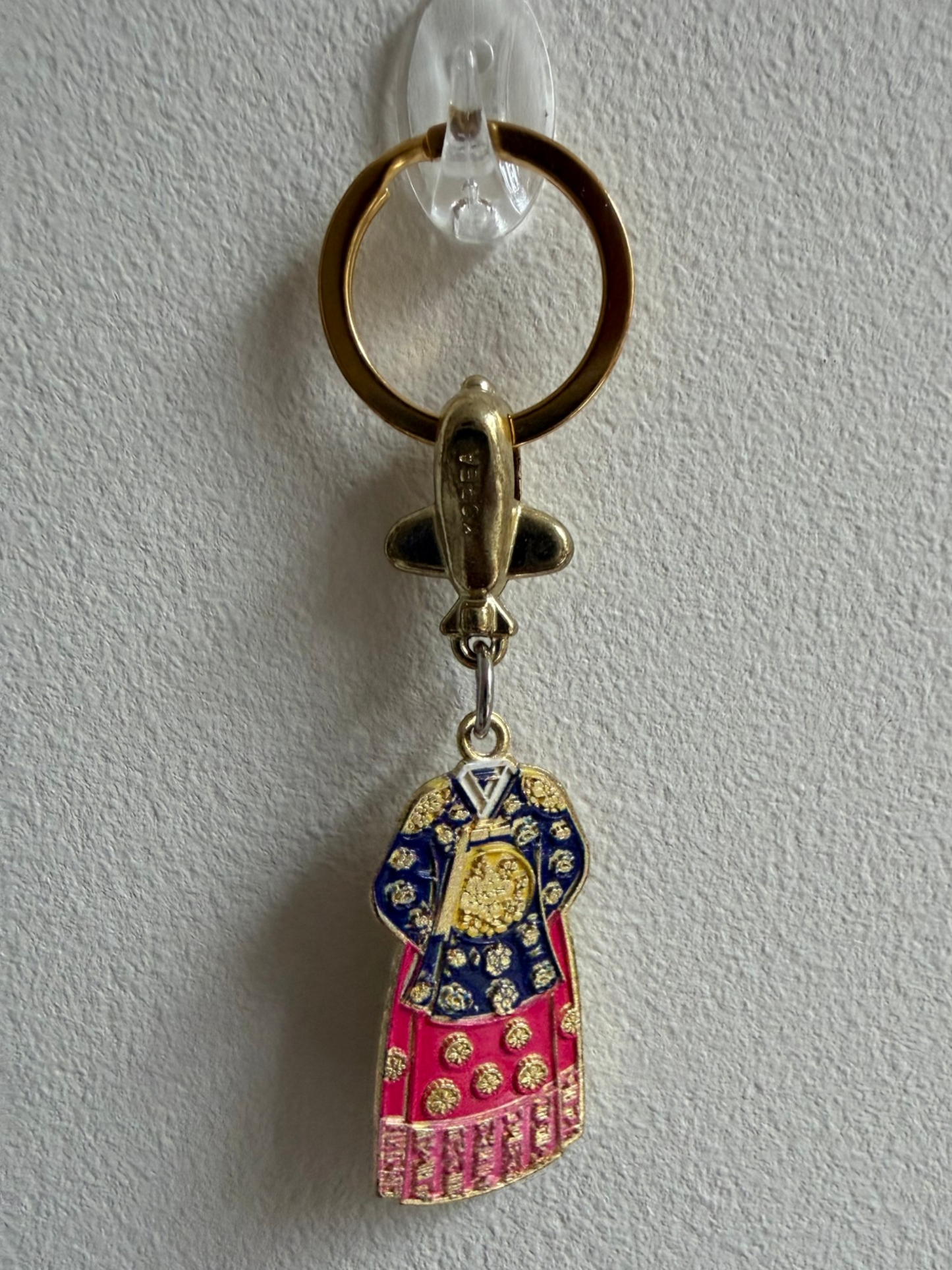 Porte-clés WANGBOK — vue de face, détails broderies dorées sur fond bleu marine et rose